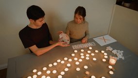 Exchanging playing cards with glowing candles, boy and girl performing ritual. Holding cards in candlelit room, children practicing magic. Sharing cards surrounded by light, teenagers engaging in - Powered by Shutterstock - Get 15% off with code: PIKWIZARD15