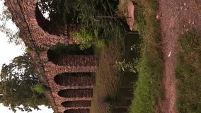 Vertical video panning left of small stream with brick wall and house during summer sunset. - Powered by Shutterstock - Get 15% off with code: PIKWIZARD15