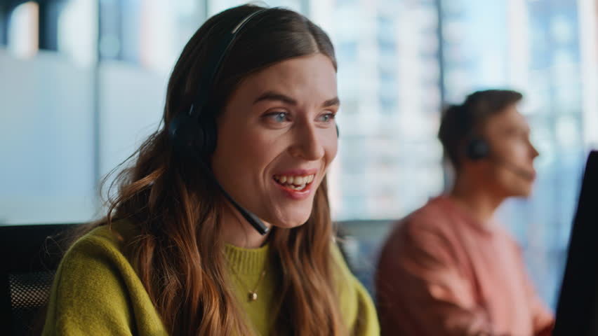 Consultant hands entering data on keyboard talking with client by headset closeup. Happy woman call center operator consulting customer. Friendly sales agent proposing company services typing computer