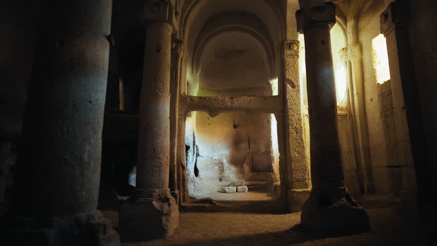 Historic rock-carved church in Cappadocia, Turkey, showcasing arched ceilings, stone columns, and soft natural light. A timeless piece of Byzantine Christian heritage and architecture.