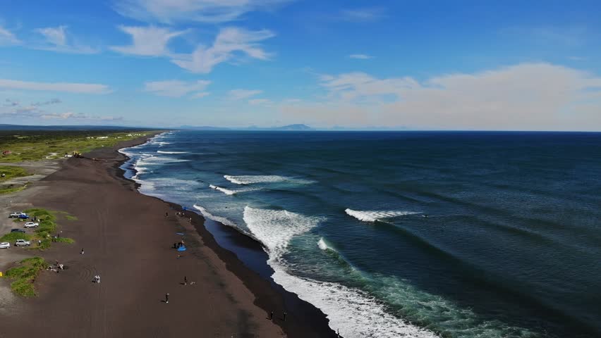White glamping on Landscape of Khalaktyrsky beach with black volcanic sand coast of North Pacific Ocean Kamchatka Russia, aerial top view.