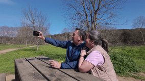 Senior couple enjoying leisure time taking selfies in a park - Powered by Shutterstock - Get 15% off with code: PIKWIZARD15