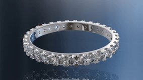 Diamond eternity ring rolling on blue glossy background. Seamless loop 3D animation - Powered by Shutterstock - Get 15% off with code: PIKWIZARD15