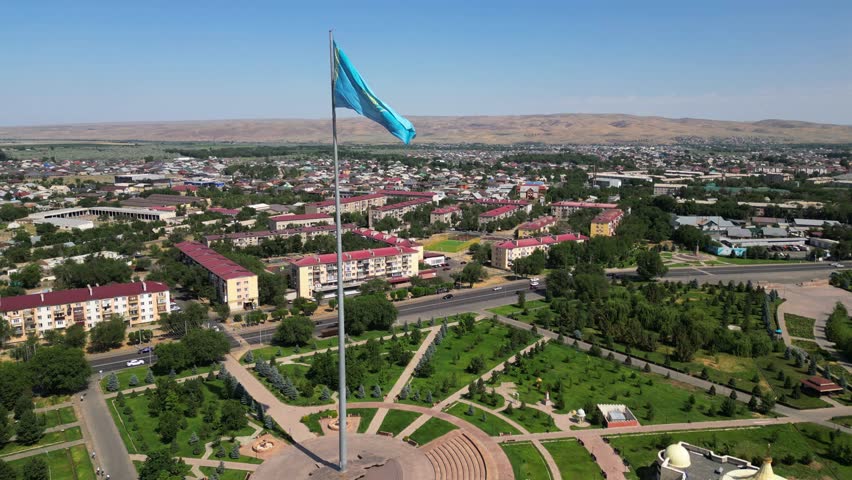 The flag of the Republic of Kazakhstan on the background of the city. The view from the drone.