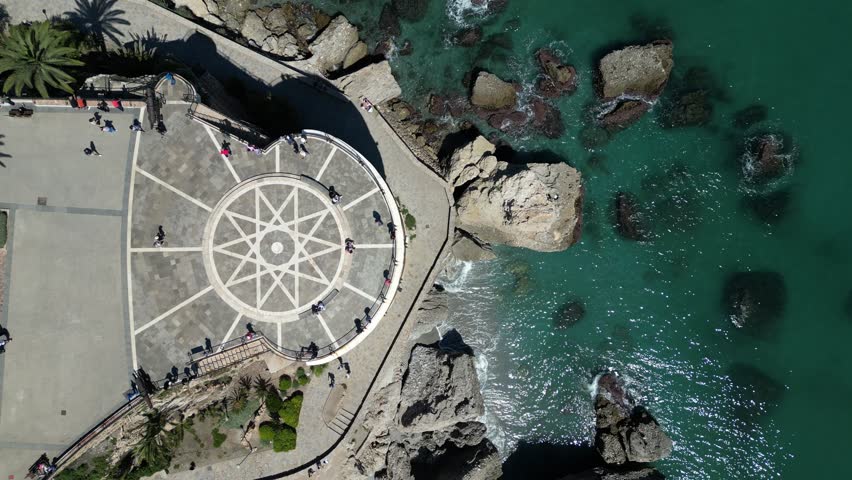 Aerial view of Balcon de Europa with beautiful coastline, sandy beach, and palm trees, Nerja, Malaga, Spain.