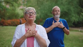 Healthy senior couple holding hands on chest, breathing fresh air, relaxing after yoga stretch, practicing mindfulness and meditation - Powered by Shutterstock - Get 15% off with code: PIKWIZARD15