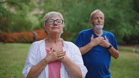 Healthy senior couple holding hands on chest, breathing fresh air, relaxing after yoga stretch, practicing mindfulness and meditation - Powered by Shutterstock - Get 15% off with code: PIKWIZARD15