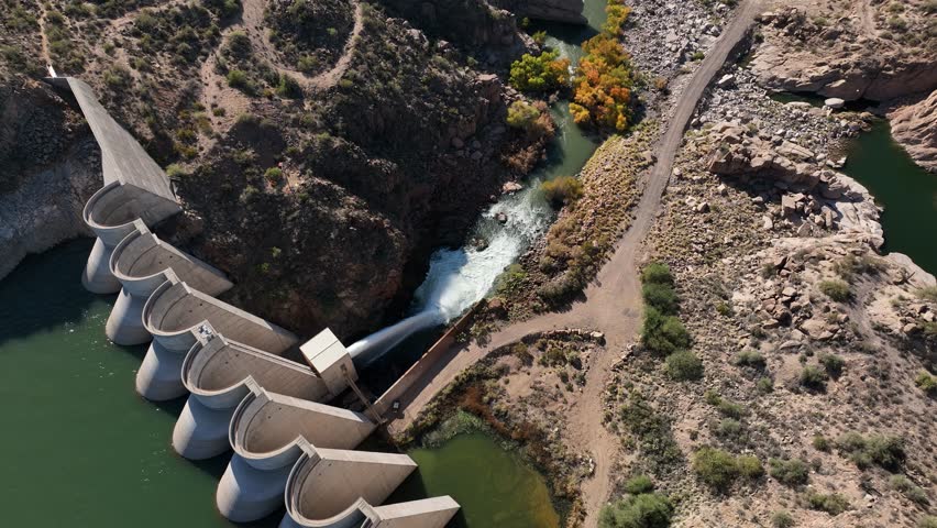 Aerial view of a scenic dam and river in a rugged valley surrounded by rocky terrain, Rio Verde, Arizona, United States.