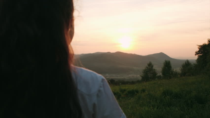 Adorable happy preteen girl holding paper smiley face icon over amazing sunset sky and beautiful mountains. Business customer service evaluation and feedback rating concept