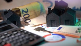 housing market hand placing a miniature house real estate economy - Powered by Shutterstock - Get 15% off with code: PIKWIZARD15