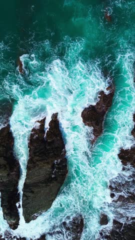Vertical Drone Footage of Ocean Waves Crashing on Rocky Cliffs for Social Media Reels. Vertical ocean drone video of waves crashing on rocky cliffs, ideal for reels, TikTok, Shorts, and ads.