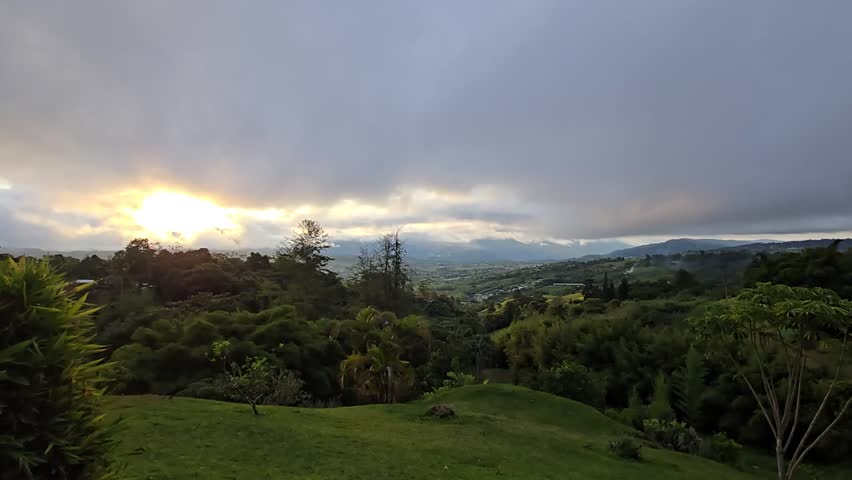 Time lapse of scenic landscape in El Carmen, Valle del Cauca, Colombia with dramatic moving clouds, changing natural light, rural mountains, lush greenery and serene Andean countryside views