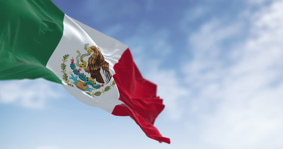The national flag of Mexico, featuring the iconic coat of arms: a golden eagle devouring a snake while perched on a cactus. Seamless 3d render animation. Slow motion loop. Selective focus
