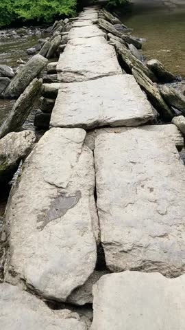 Ancient stone clapper bridge across across the river Barle at Dulverton in the Exmoor National Park area of Somerset. This is known as Tarr Steps and 180 feet long. Each stone weighs about 2 tonnes.