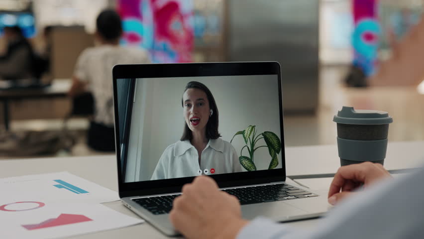 Portrait of businesswoman participating in video conference laptop screen view. Female counselor discusses project with customer using video chat in contemporary office environment