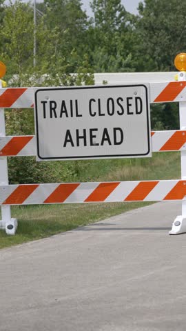 A vertical bicyclist rides past a closed trail sign and takes a detour. 14681	