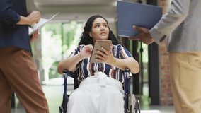Woman in wheelchair tapping tablet tracking social icons fluctuating around screen for marketing. Assistive technology, accessibility, teamwork, digital interaction, corporate, innovation, diversity - Powered by Shutterstock - Get 15% off with code: PIKWIZARD15