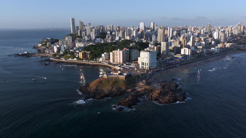 Aerial view of Salvador cityscape with the historic Barra Lighthouse at sunset in Bahia, Brazil. 