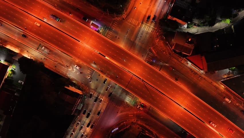 car traffic transportation on road at junction intersection, 4K. Aerial view of road interchange or highway intersection with busy urban traffic speeding on the road at night. expressway, highway road