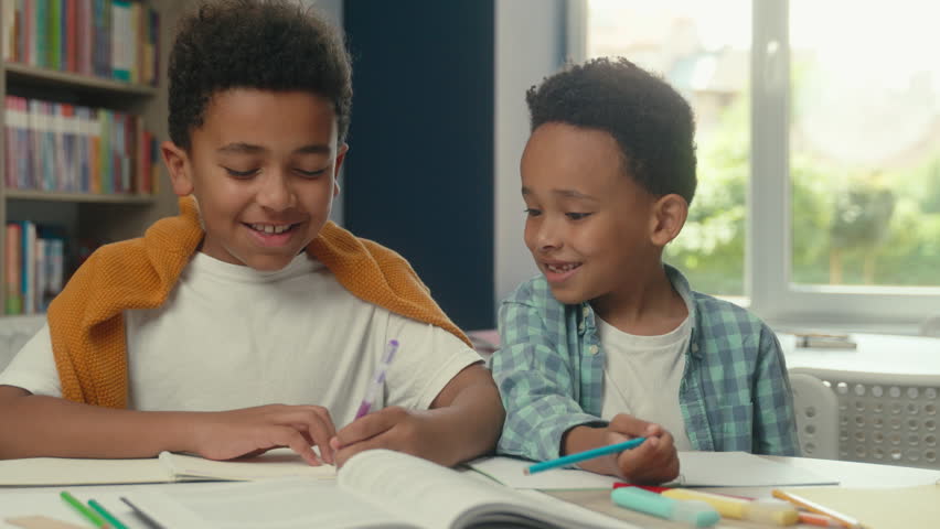 Elementary primary school education two kids African American smiling little boys pupils students children schoolboys writing test exam lesson drawing at table together studying learning in classroom - Powered by Shutterstock - Get 15% off with code: PIKWIZARD15