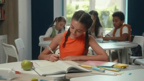 Caucasian girl kid pupil school student teen studying at desk classroom smiling schoolgirl learning writing task lesson exam knowledge primary education child looking at camera happy portrait children - Powered by Shutterstock - Get 15% off with code: PIKWIZARD15