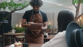 Smiling Indian man Arabian latino guy friendly cafe worker barista in apron chef cafe customer service talk client order food lunch dinner in restaurant digital tablet serving visitor in coffee shop - Powered by Shutterstock - Get 15% off with code: PIKWIZARD15