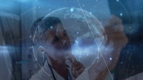 Doctor studying spinning holographic globe before monitors and tapping data nodes during analysis. Healthcare, technology, data, visualization, innovation, diagnostics, science - Powered by Shutterstock - Get 15% off with code: PIKWIZARD15