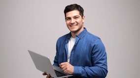 A cheerful young man engages with a laptop, embodying a spirit of innovation and approachability in a simple backdrop. - Powered by Shutterstock - Get 15% off with code: PIKWIZARD15