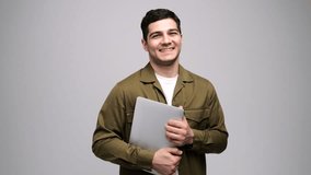 Smiling Young Professional in Casual Attire Holds a Laptop With Confidence, Showcasing a Blend of Modern and Approachable Style - Powered by Shutterstock - Get 15% off with code: PIKWIZARD15