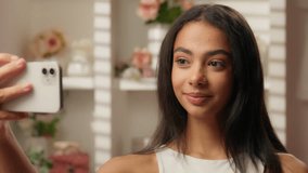 Happy Latina teen girl smiling cheerful Hispanic woman female fashion blogger stylist influencer in pink candy bathroom selfie mobile phone beauty blog video social media hair care skincare cosmetics - Powered by Shutterstock - Get 15% off with code: PIKWIZARD15