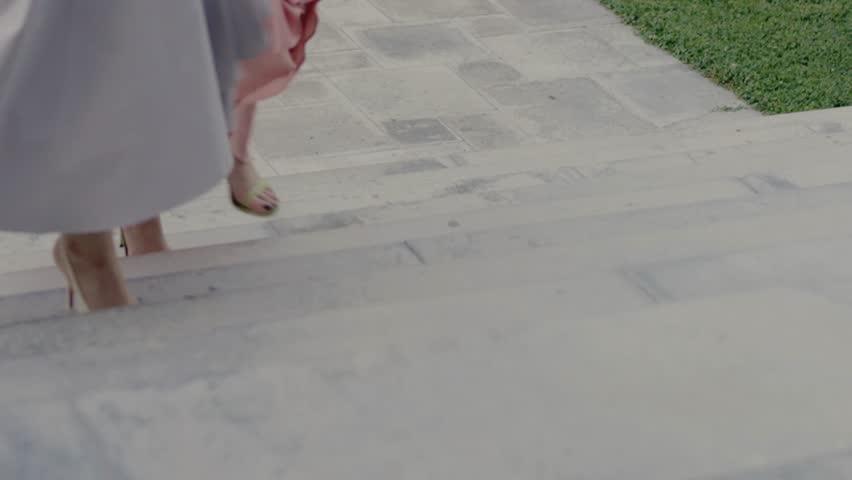 Close-up of women ascending stone steps wearing stylish high heels. Elegant footwear, movement, grace, and sophistication are highlighted. Fashionable Women Walking Up Steps in High Heels