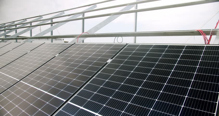 Surface of solar panels in daytime. Closeup handheld shot of modern photovoltaic panels illuminated with sunlight in daytime on solar farm. Concept renewable energy, technology, electricity, service.
