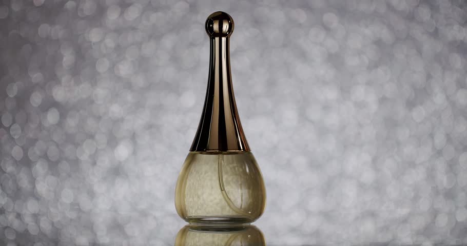 Sophisticated perfume bottle displayed against a shimmering, bokeh background. Ideal for beauty, fashion, and luxury themes. Elegant Perfume Bottle on Sparkling Bokeh Background for Beauty and Fashion