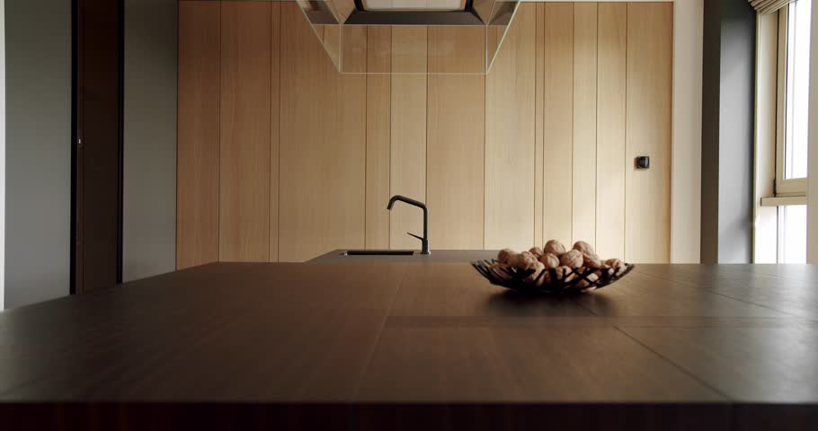 Modern interior in luxury house. Interior of a minimalist kitchen. Light Wood Wall and Floors. Domestic Kitchen with modern sink. Stylish interior of the Kitchen. Real Luxury kitchen with an island.