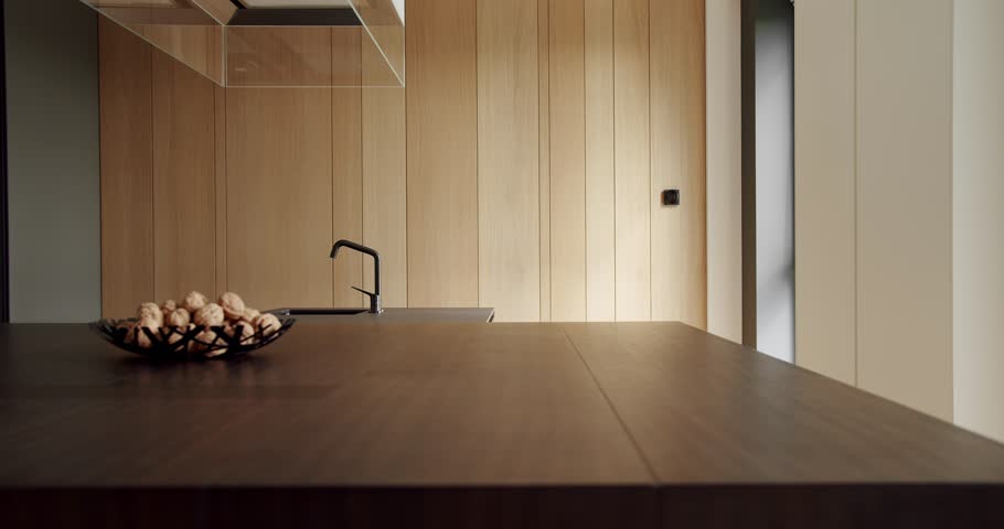 Modern interior in luxury house. Interior of a minimalist kitchen. Light Wood Wall and Floors. Domestic Kitchen with modern sink. Stylish interior of the Kitchen. Real Luxury kitchen with an island.