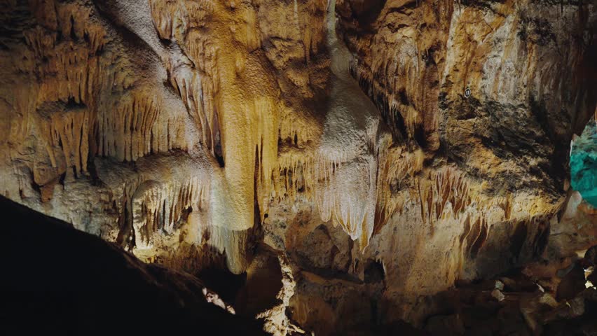 Explore the depths of a breathtaking Portuguese cave featuring spectacular stalactites and rock formations, illuminated by ambient lighting. Majestic Cave Formations Captured in Stunning Detail