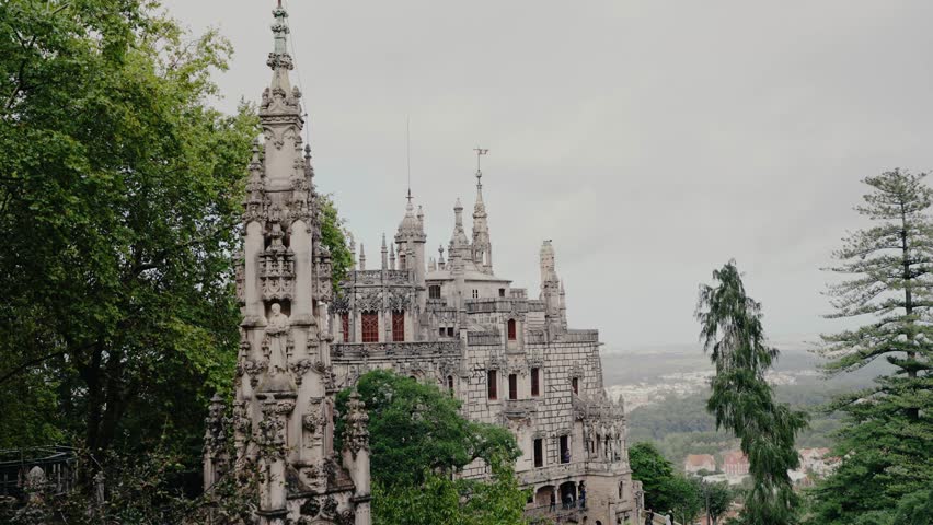 Stunning view of the Gothic palace and ornate detailing of Quinta da Regaleira amidst lush greenery in Sintra, Portugal. Ancient Gothic Architecture of Sintra Portugal with a Scenic Mountain View