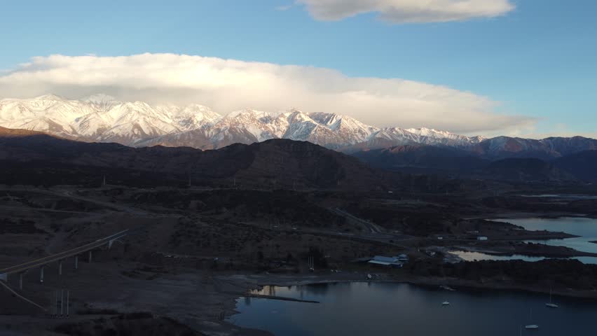 Aerial drone view of the Andes mountains and route 7 (Ruta 7) from Potrerillos, Mendoza, Argentina, showcasing the majestic peaks and rugged terrain against a clear sky