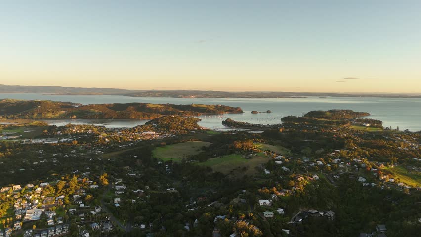 Breathtaking 4K panoramic high aerial views of Waiheke Island, New Zealand, bathed in the warm, dramatic light of sunset.