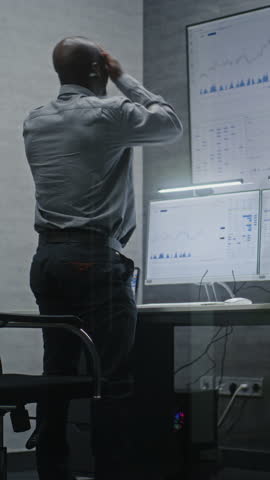Stock Trader Soaking Financial Loss, Shouting in Phone, Monitoring Real-Time Stocks, Exchange Market Charts in Office. African American Investment Agent Angry About Bad Economy News. Vertical Shot.