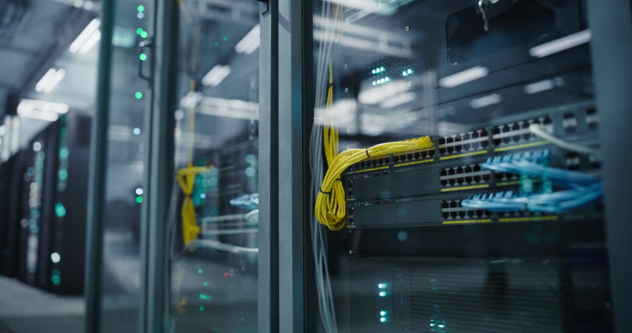 Establishing Shot with Advanced AI Data Center with Close Up on Server Racks in a Modern Facility. Female IT Technician Walking with a Laptop in the Corridor. Specialist on Her Way to Install Updates