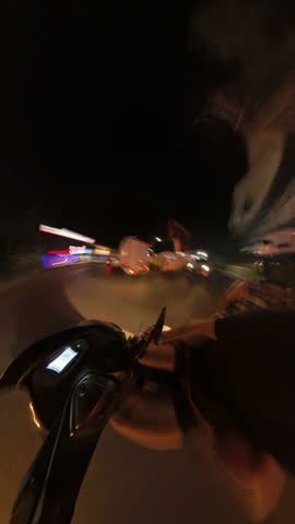 First-Person Timelapse View of Riding a Motorcycle at Night on Empty Street with Motion Blur and Light Trails for High-Speed Urban Travel Concept.