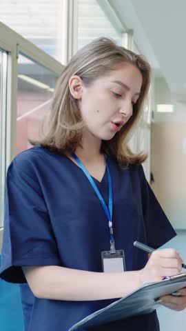 Nurse taking notes in slow motion in hospital corridor