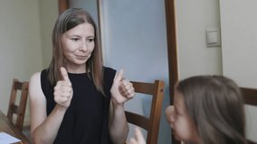 Woman teaching sign language to a young girl at home - Powered by Shutterstock - Get 15% off with code: PIKWIZARD15