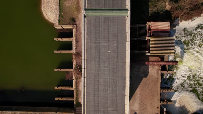 Birdseye shot of a damn pumping water into a river in the French countryside
