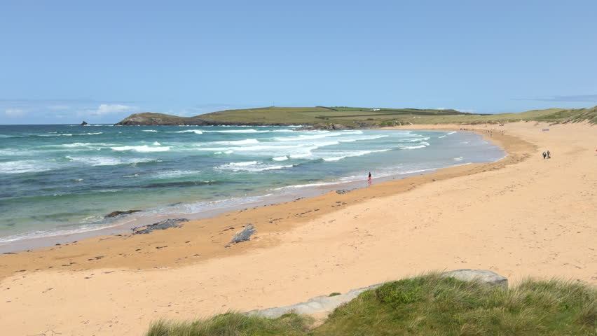 Constantine Bay, Cornwall, England on a sunny summer day with blue sky and white surf.