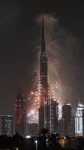 Huge bright fireworks and festive salute from Burj Khalifa skyscraper at night. New Year and Christmas celebration in Dubai, United Arab Emirates. Downtown and business center with new architecture