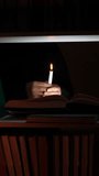 vertical video Person reading a book by candlelight in a dark library - Powered by Shutterstock - Get 15% off with code: PIKWIZARD15