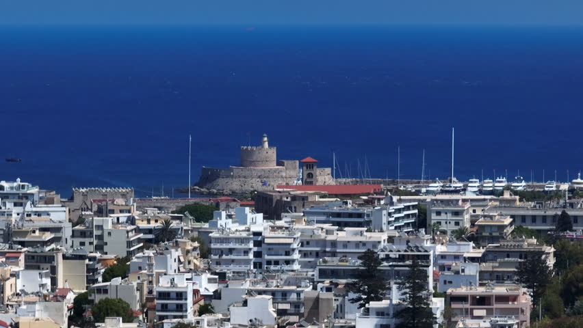 Aerial view circling the Colossus of Rhodes and the city, sunny day in Greece