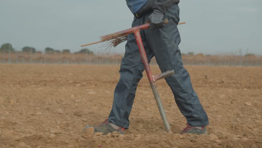 close-up of a farmer walking through a field with testing equipment for data